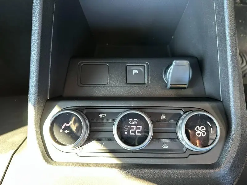 Vue rapprochée de la console centrale du DACIA JOGGER 2024, montrant les commandes de climatisation et prise 12V.