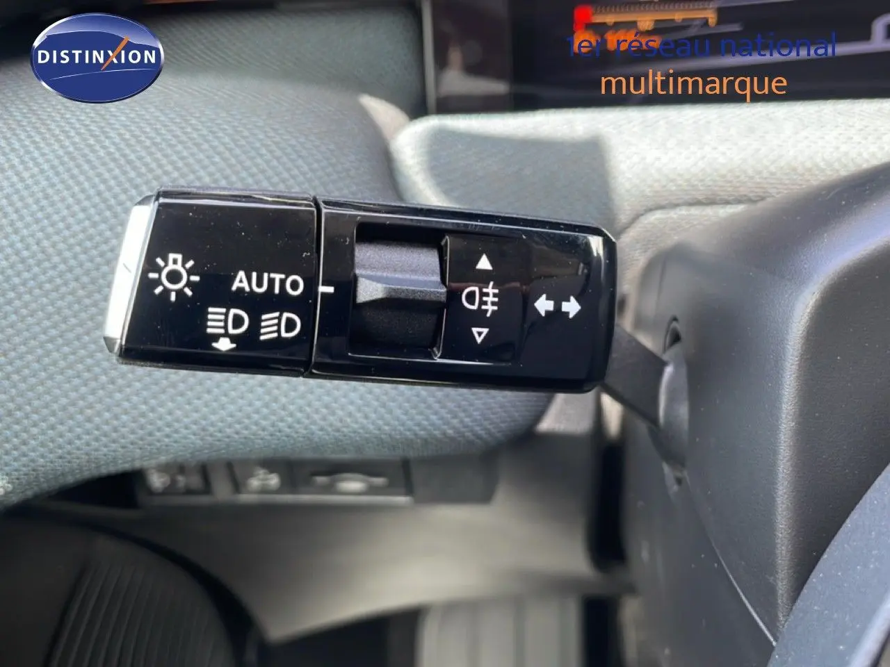 Gros plan sur la commande des feux et clignotants à gauche du volant dans un Citroën C5 Aircross Hybrid rouge rubis métal.