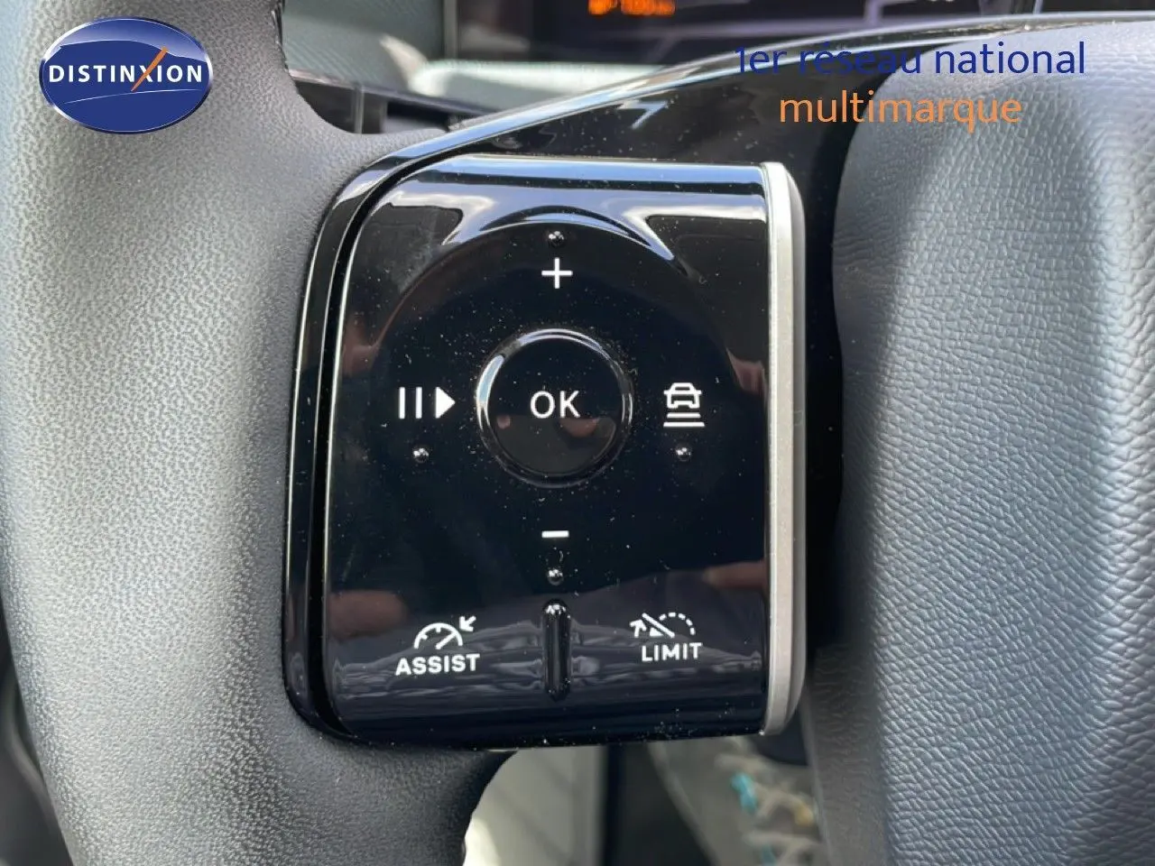 Gros plan sur les commandes du volant du Citroën C5 Aircross Hybrid rouge rubis, avec boutons de régulateur et limiteur de vitesse.