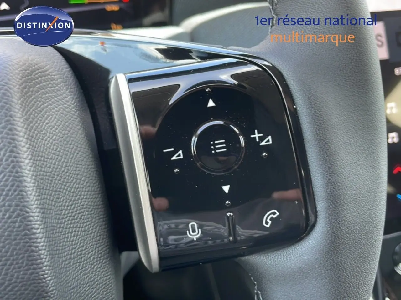 Gros plan sur les commandes multifonctions noires du volant d’un Citroën C5 Aircross hybride rouge rubis.