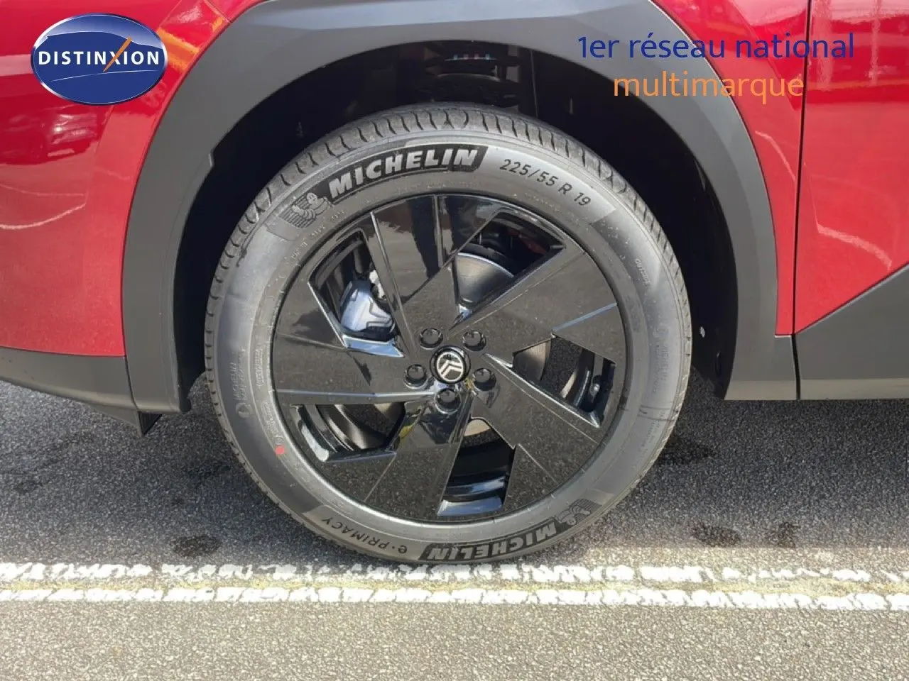 Gros plan sur la roue avant droite noire brillante du Citroën C5 Aircross Hybrid rouge rubis métallisé.