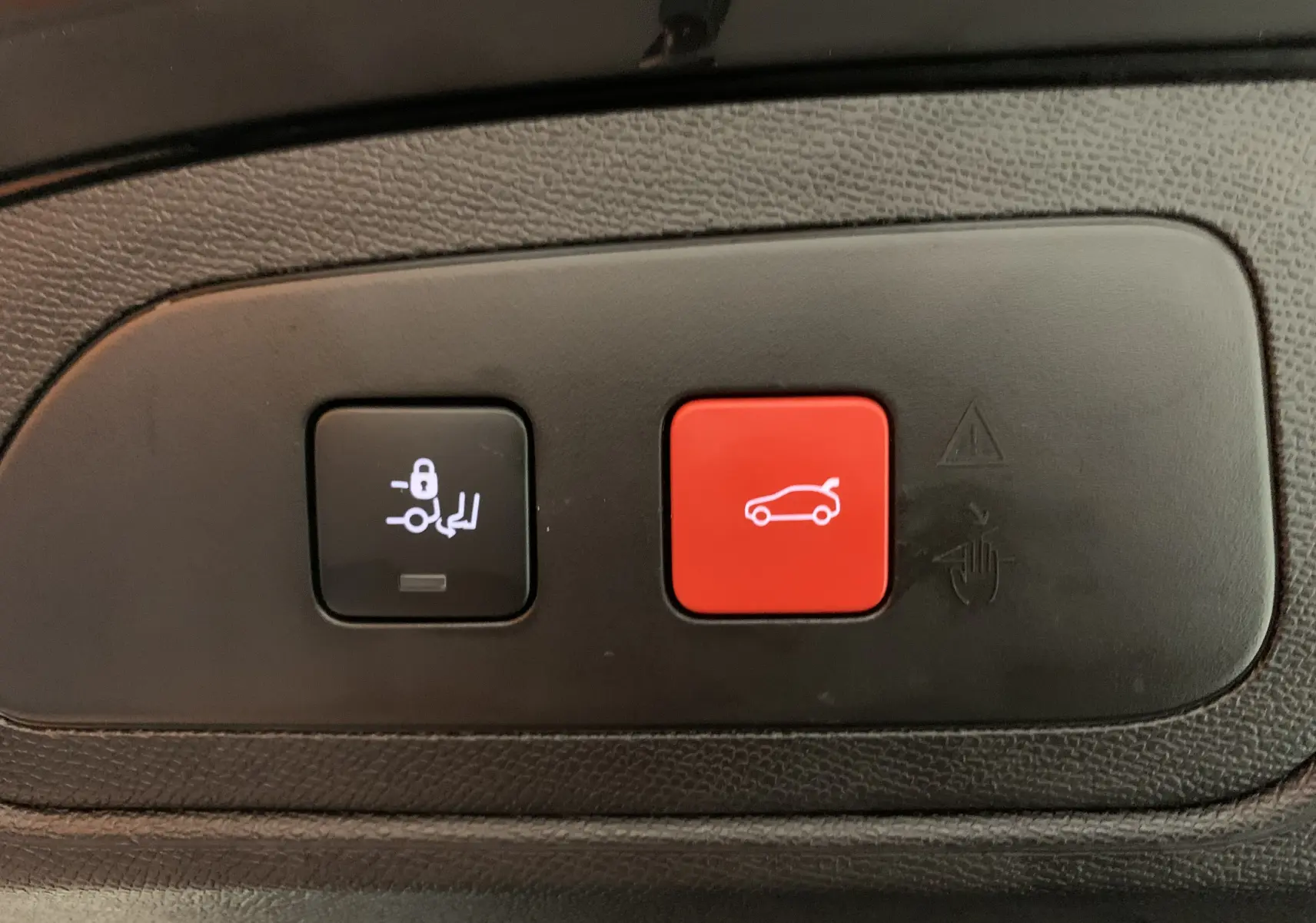 Gros plan sur les boutons de commande du hayon et du verrouillage du coffre du DS7 Crossback gris Platinium 2022.