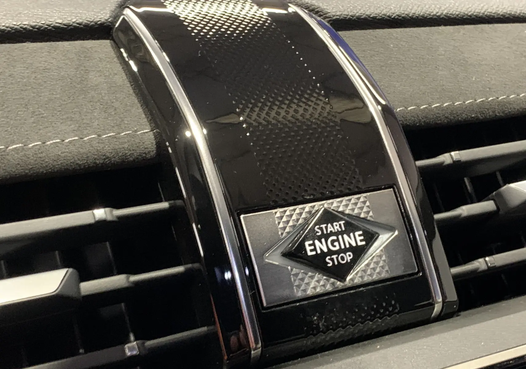 Bouton Start Engine Stop noir brillant avec motif géométrique sur la console centrale du DS7 Crossback Gris Platinium 2022