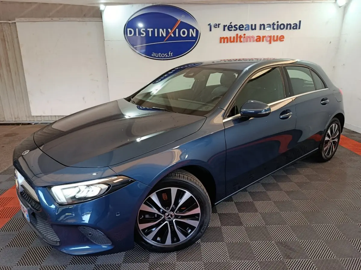 Mercedes Classe A 250 e Business Line bleu, vue 3/4 avant droit avec phares LED allumés et jantes distinctives.