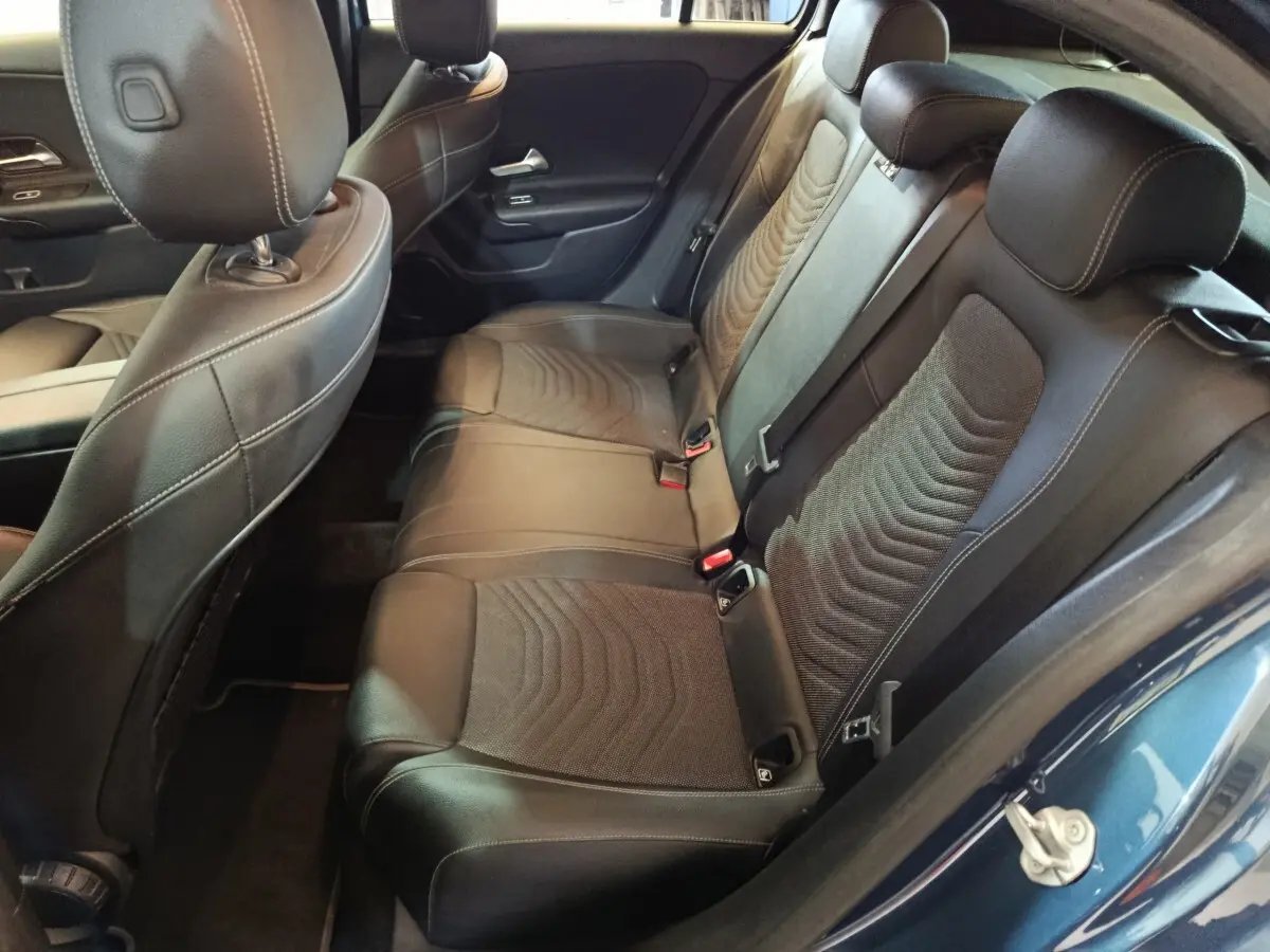 Vue intérieure côté arrière droit de la banquette en cuir noir de la Mercedes Classe A 250 e Business Line bleu.