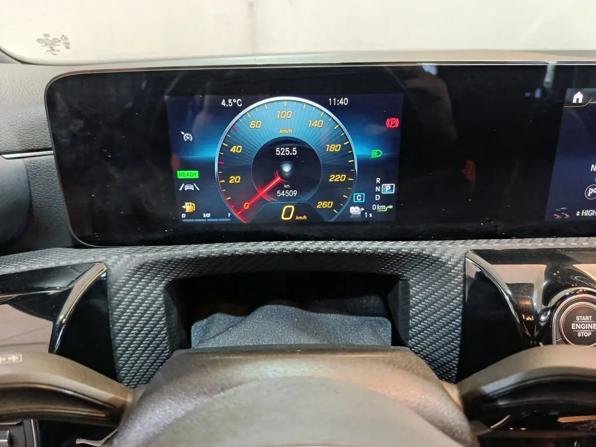 Vue rapprochée du tableau de bord numérique de la Mercedes Classe A bleu, affichant la vitesse et les indicateurs.