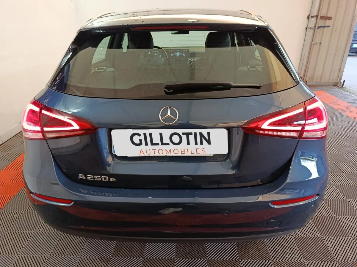 Vue arrière d'une Mercedes Classe A 250 e Business Line bleu avec feux LED allumés dans un garage.