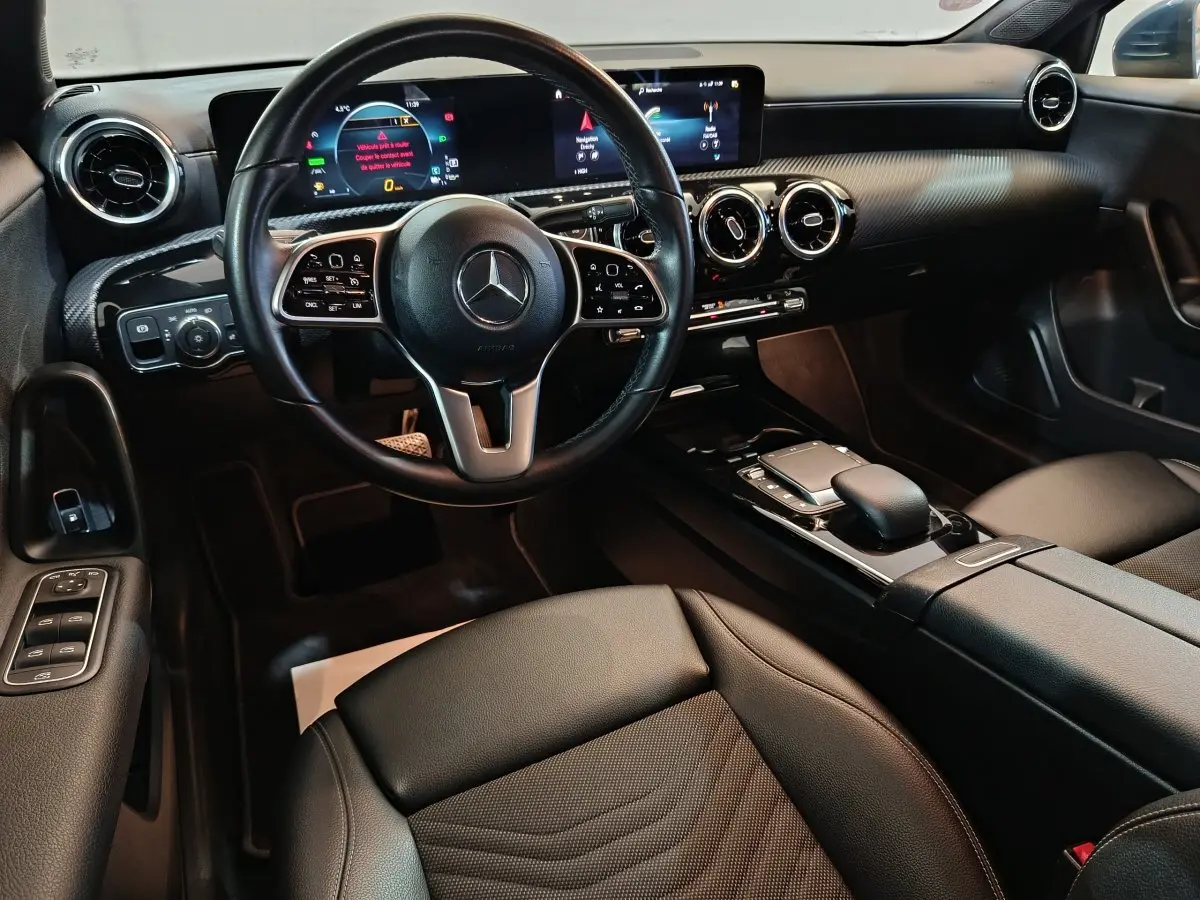 Vue intérieure avant de la Mercedes Classe A 250 e Business Line 2021, volant cuir multifonctions et écran tactile large.