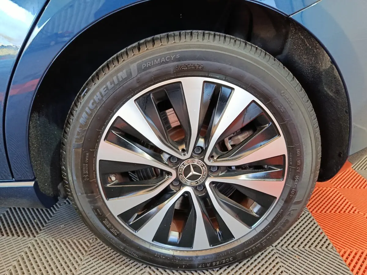 Gros plan sur la roue avant droite d'une Mercedes Classe A bleu, avec jante alliage bicolore et pneu Michelin.