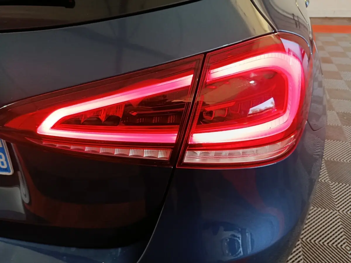 Gros plan sur le feu arrière droit rouge allumé d’une Mercedes Classe A 250 e Business Line bleu 2021.