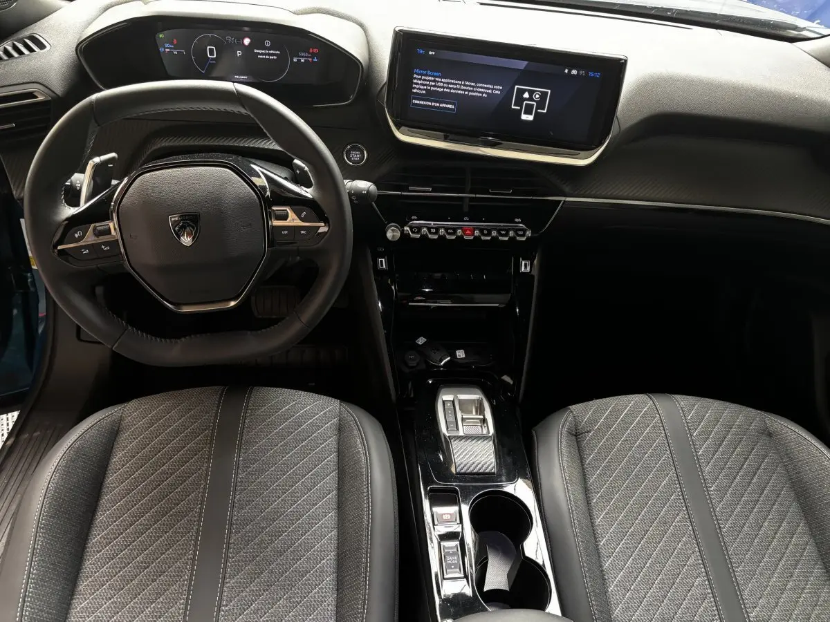 Vue intérieure avant du Peugeot 2008 Hybrid 145 Allure bleu, avec tableau de bord numérique et écran tactile central.