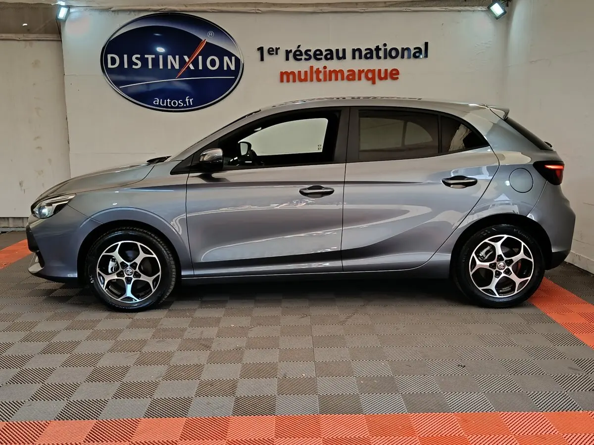 Vue de profil côté gauche d'une MG3 gris foncé 2024 avec jantes alliage et feux arrière LED en intérieur showroom.
