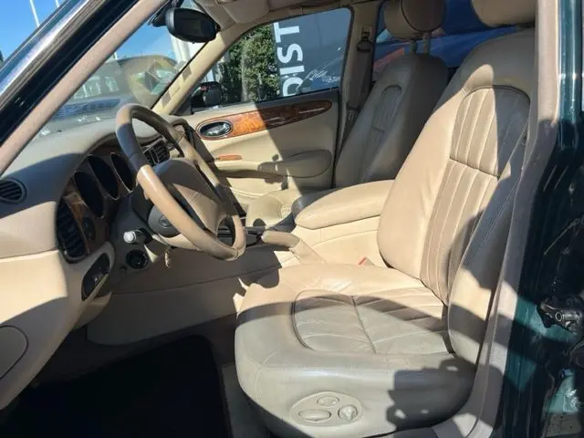 Intérieur beige clair de la Jaguar Sovereign 3.2 V8 2002, vue côté conducteur avec tableau de bord en bois et cuir.