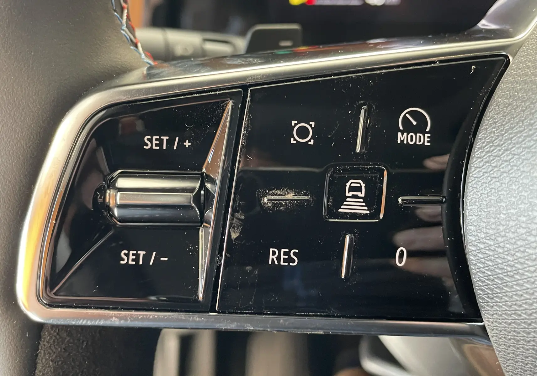 Gros plan sur les commandes de régulateur de vitesse du volant de la Renault Rafale Esprit Alpine gris schiste 2024.