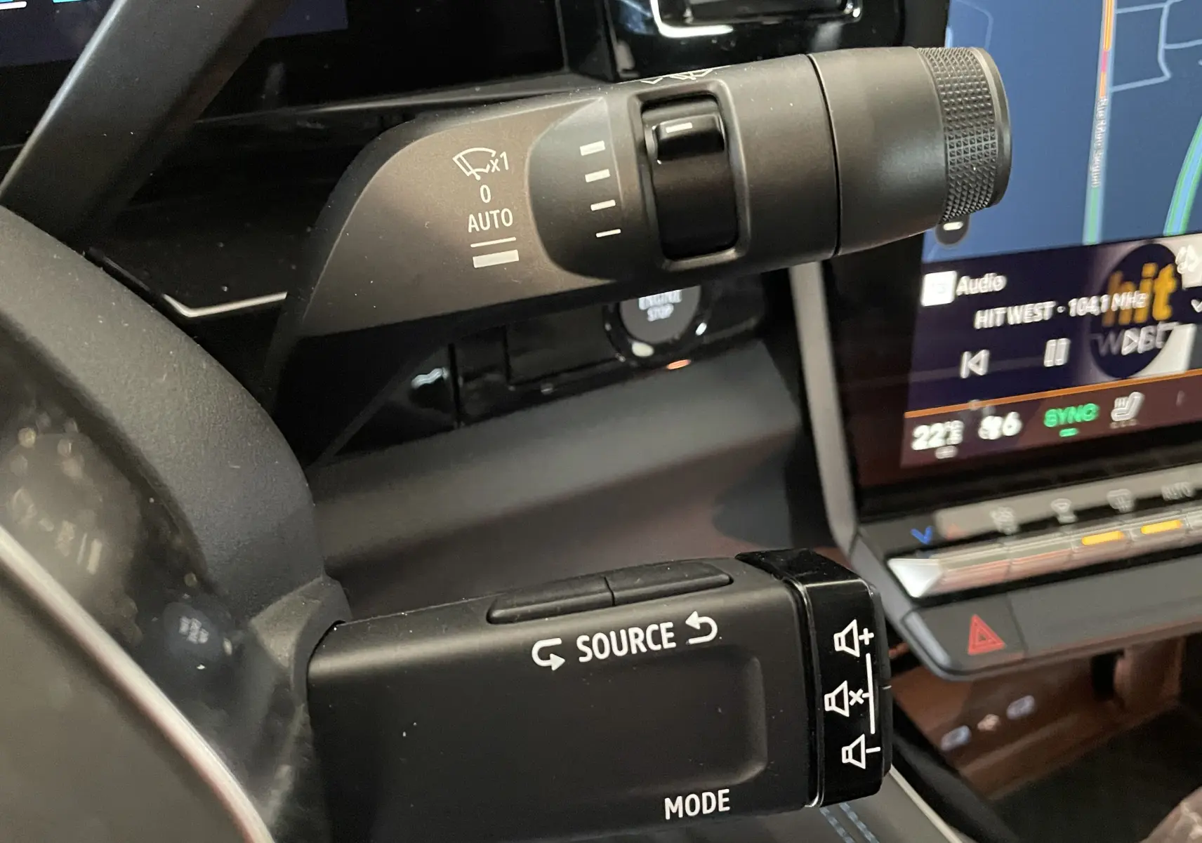 Gros plan sur les commandes au volant du Renault Rafale Esprit Alpine gris, avec écran tactile et réglages multimédia visibles.