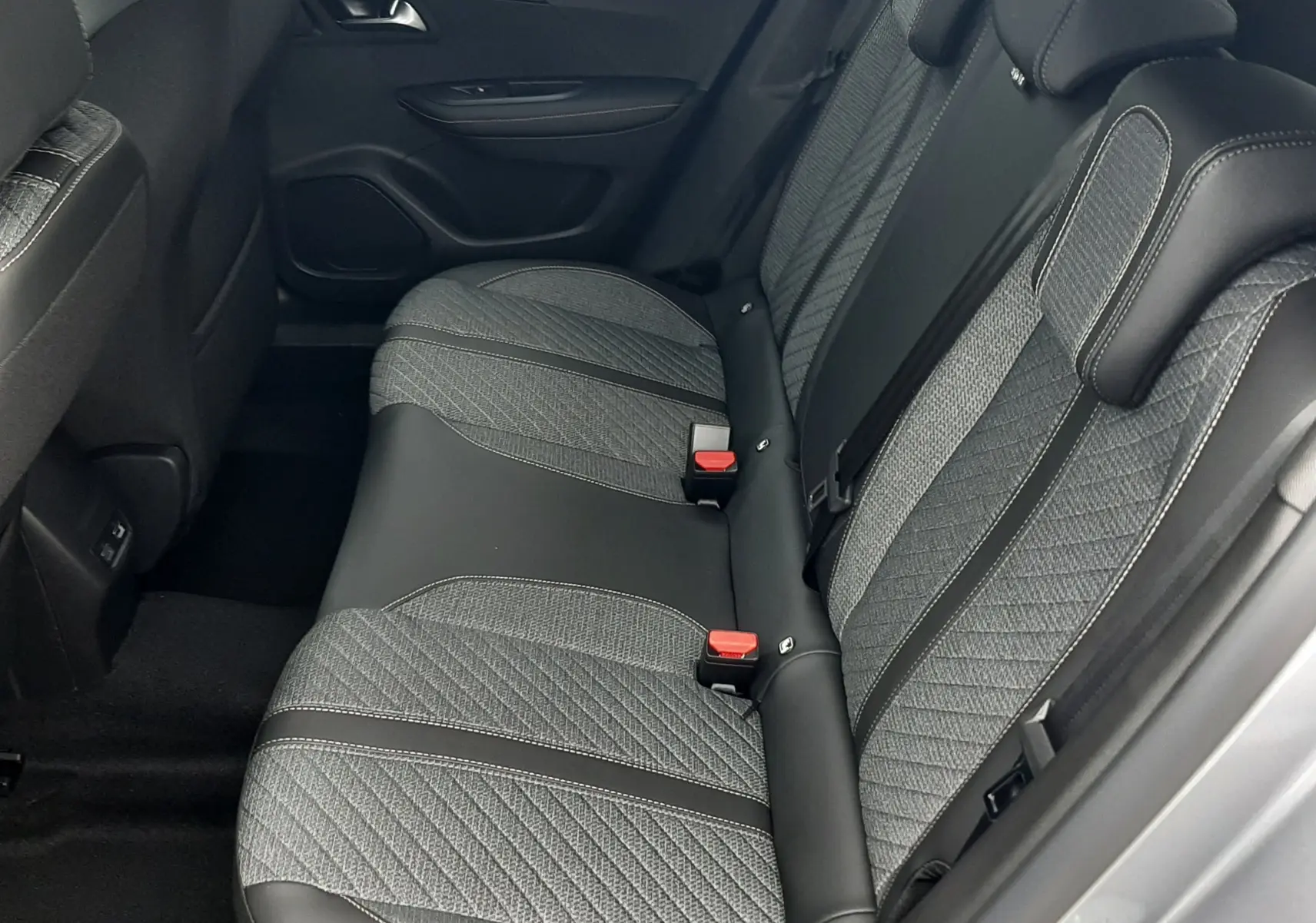 Vue latérale droite de la banquette arrière en tissu gris et cuir noir du Peugeot 2008 gris Artense 2025.