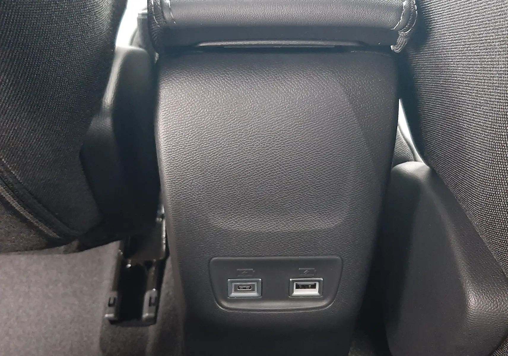 Prise USB-C et USB-A en bas du tunnel central arrière d’un Peugeot 2008 gris Artense 2025 hybride.