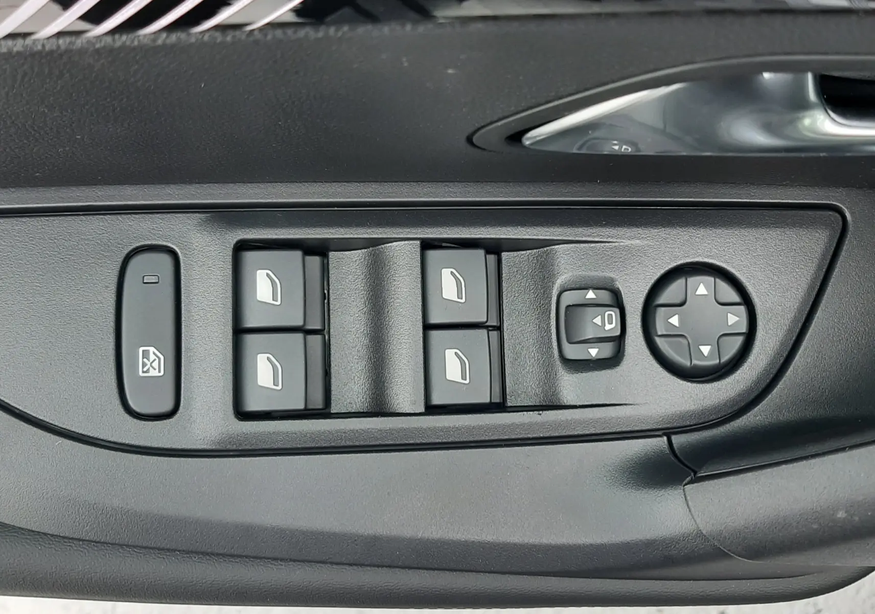 Gros plan sur les commandes des vitres et rétroviseurs côté conducteur d'un Peugeot 2008 gris Artense 2025.