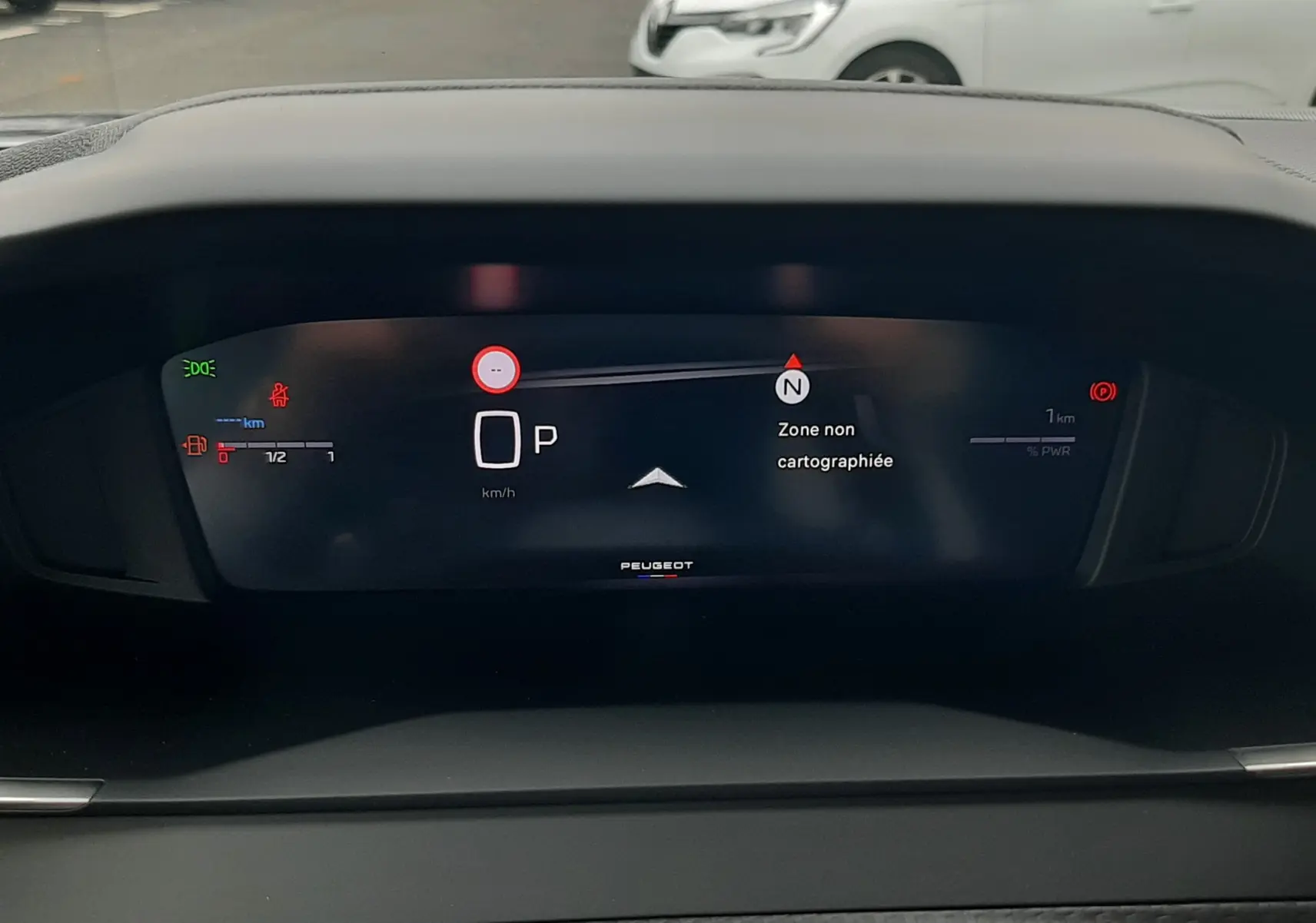Tableau de bord numérique du Peugeot 2008 gris Artense, affichant la vitesse et la navigation en mode stationnement.