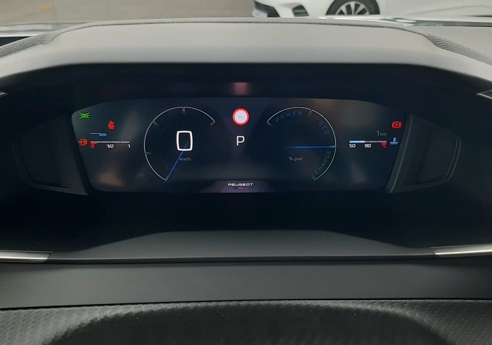 Tableau de bord numérique du Peugeot 2008 gris Artense, affichant vitesse et mode hybride en vue frontale.