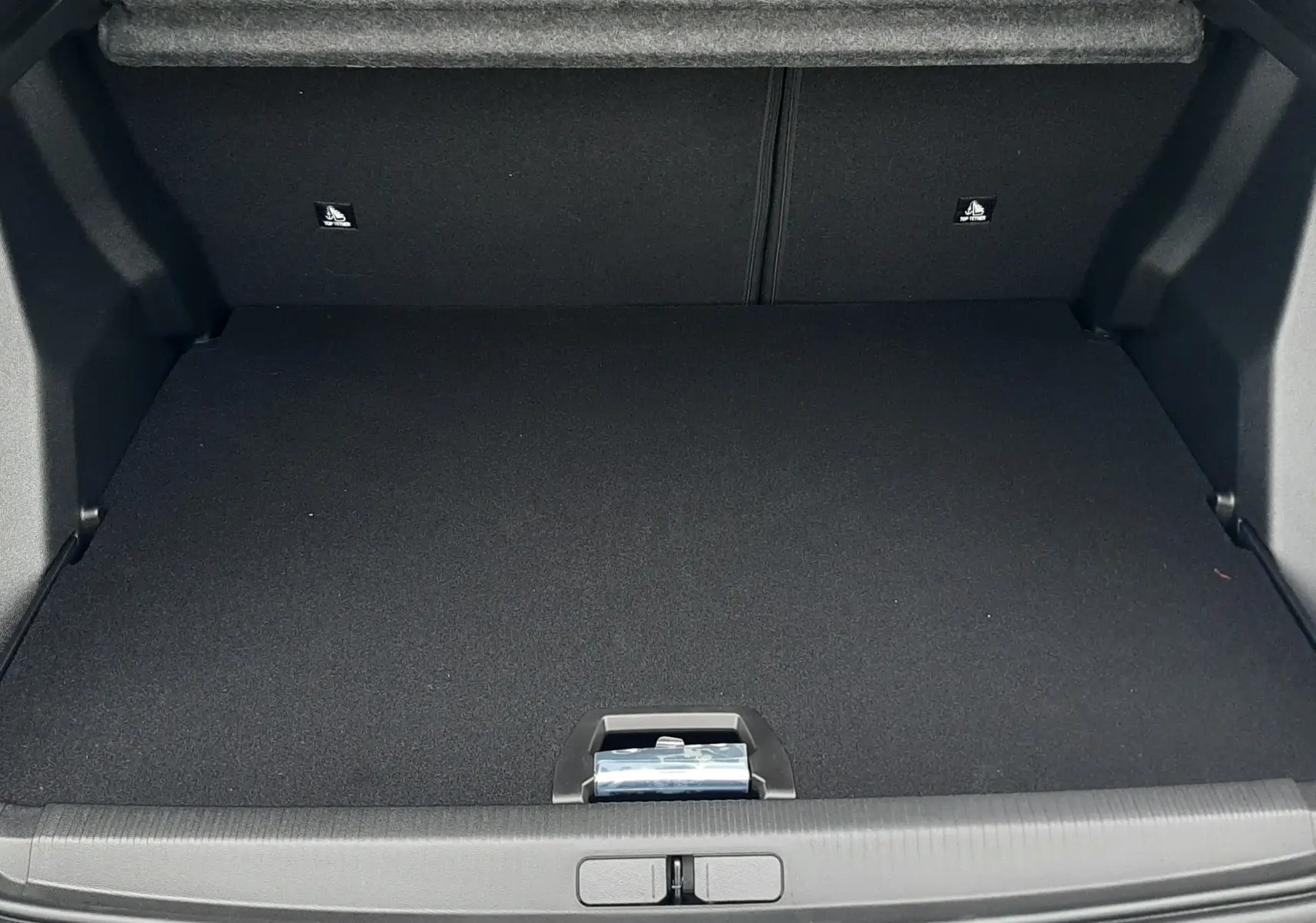 Coffre ouvert vu de face d'un Peugeot 2008 gris Artense, montrant un espace de chargement propre et spacieux.