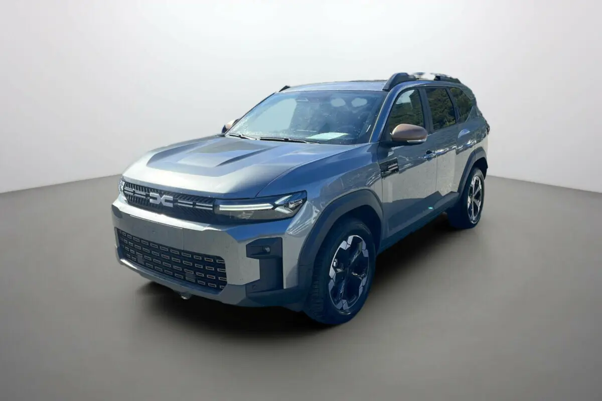 Vue 3/4 avant du Dacia Bigster gris schiste 2025 avec jantes noires et détails noirs sur les ailes.