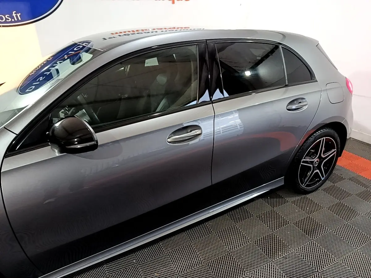 Vue latérale droite d'une Mercedes Classe A 250 e AMG Line gris foncé avec jantes noires et rétroviseur noir brillant.