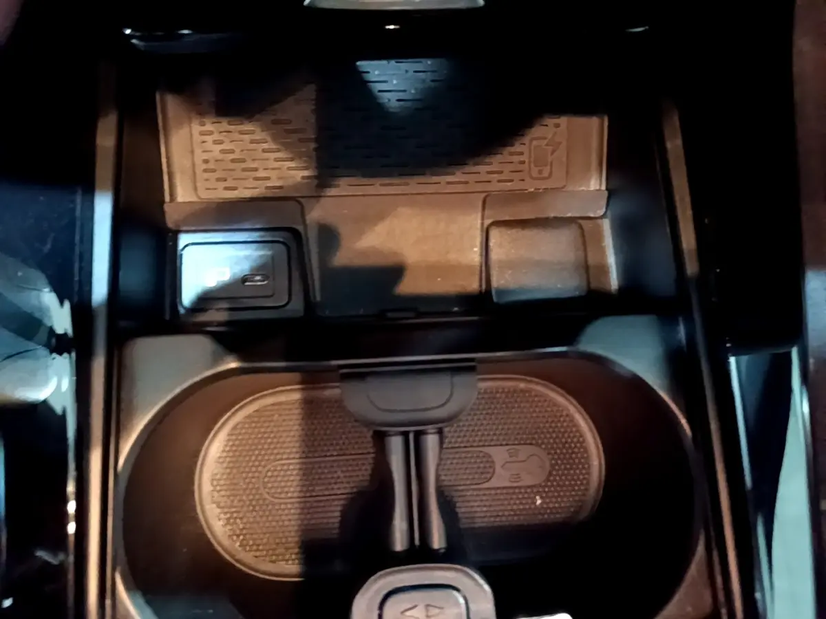 Vue rapprochée de la console centrale noire avec porte-gobelets et bouton de frein à main électrique sur Mercedes Classe A AMG Line 2021.