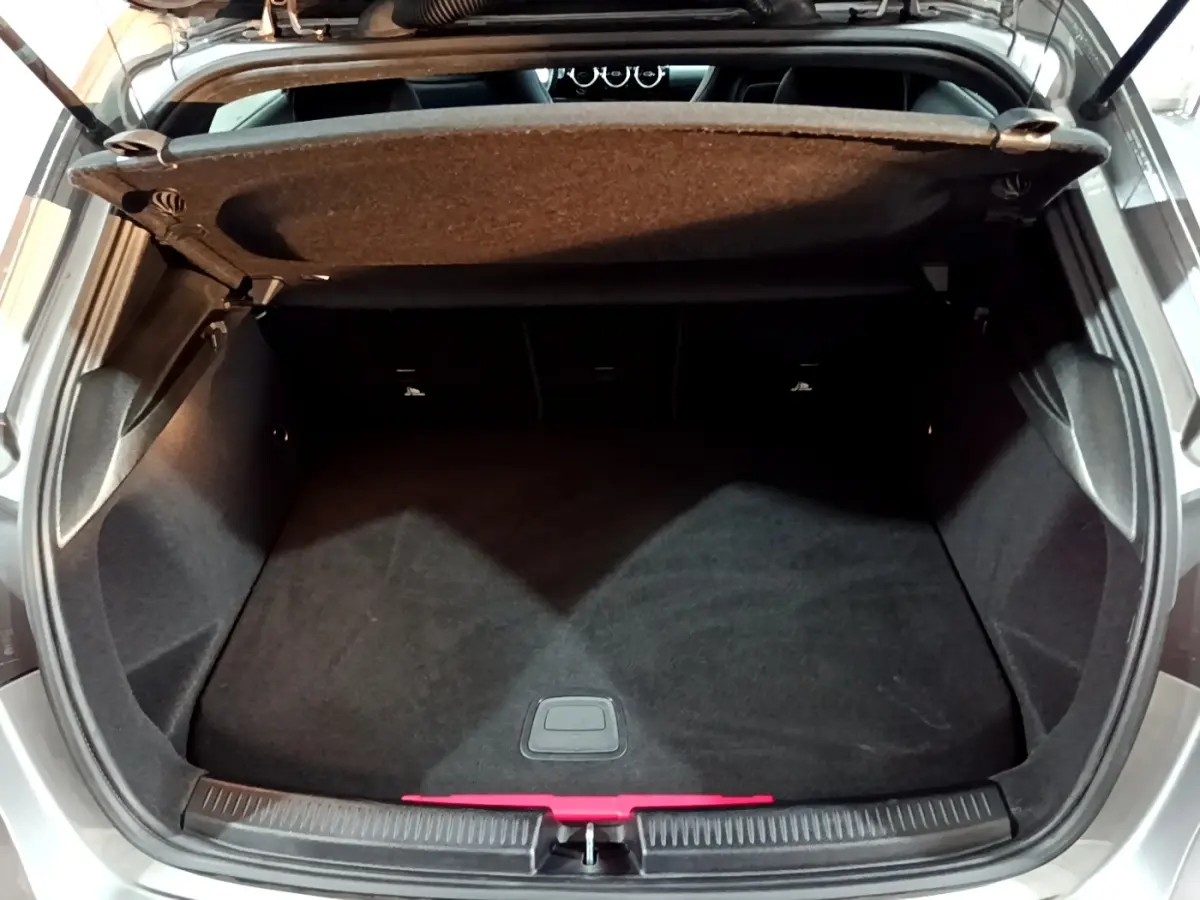 Coffre ouvert vu de dessus d'une Mercedes Classe A 250 e AMG Line gris foncé, montrant l'espace de chargement vide.