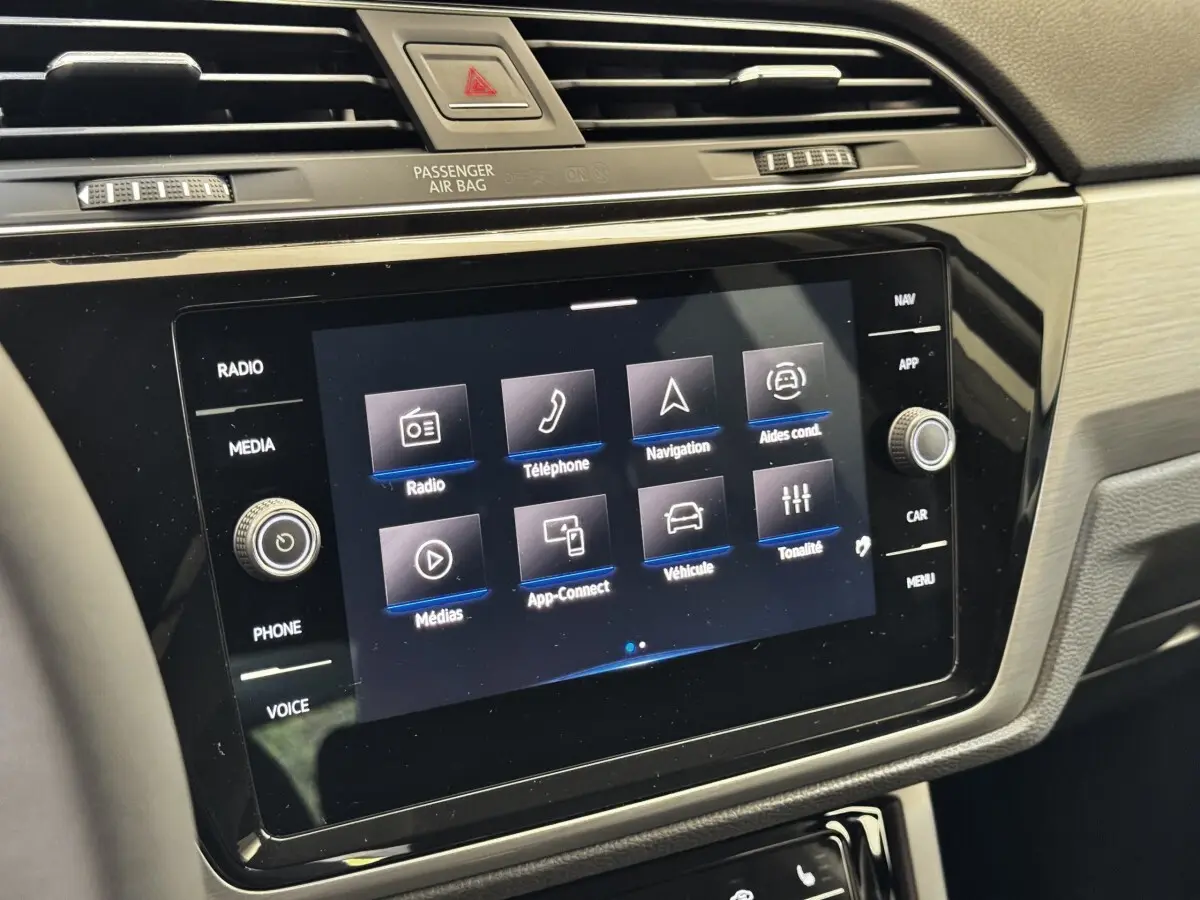 Vue rapprochée de l’écran tactile central noir du tableau de bord du Volkswagen Touran 2024, affichant le menu multimédia.