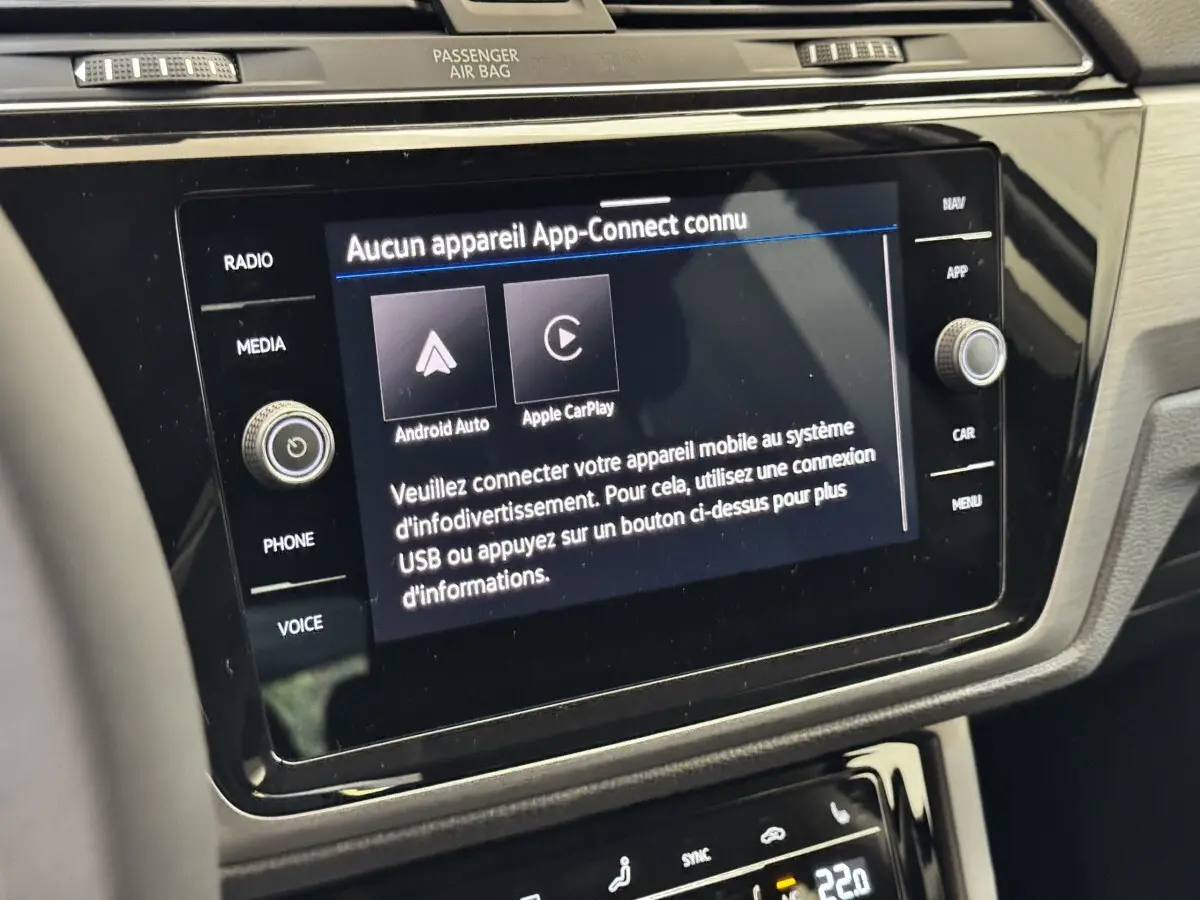 Écran tactile central du Volkswagen Touran 2024 bleu, affichant la connexion Android Auto et Apple CarPlay.