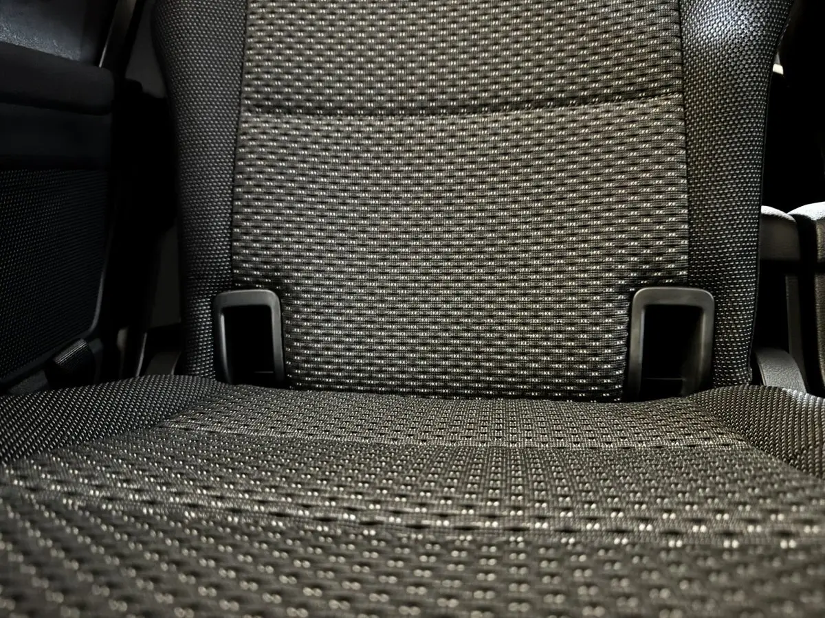 Gros plan sur le tissu gris texturé d’un siège arrière individuel du Volkswagen Touran 2024, version 7 places.