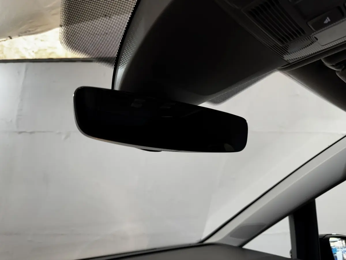 Rétroviseur intérieur noir du Volkswagen Touran 2024, vue rapprochée depuis l'habitacle côté conducteur.