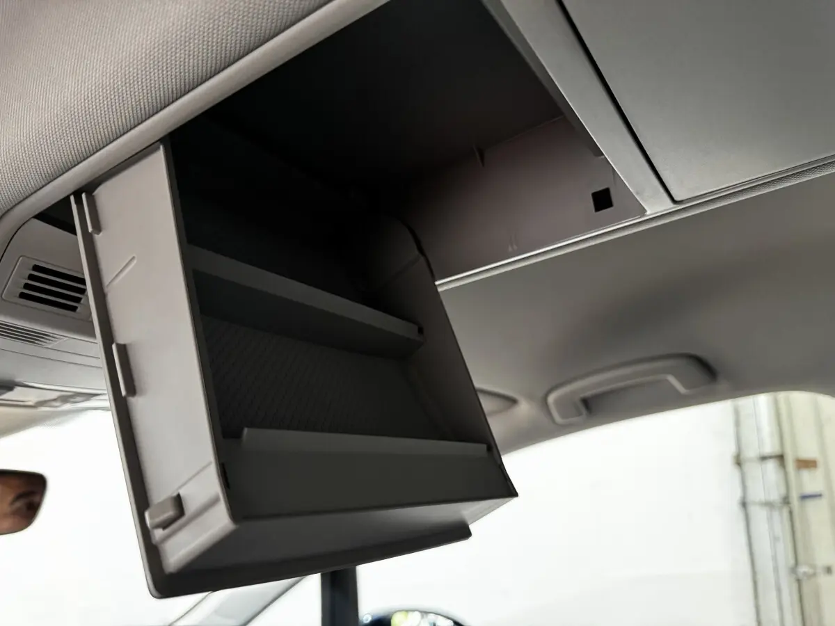 Rangement plafond ouvert dans l'habitacle d'un Volkswagen Touran 2024, vue intérieure en léger contre-plongée.