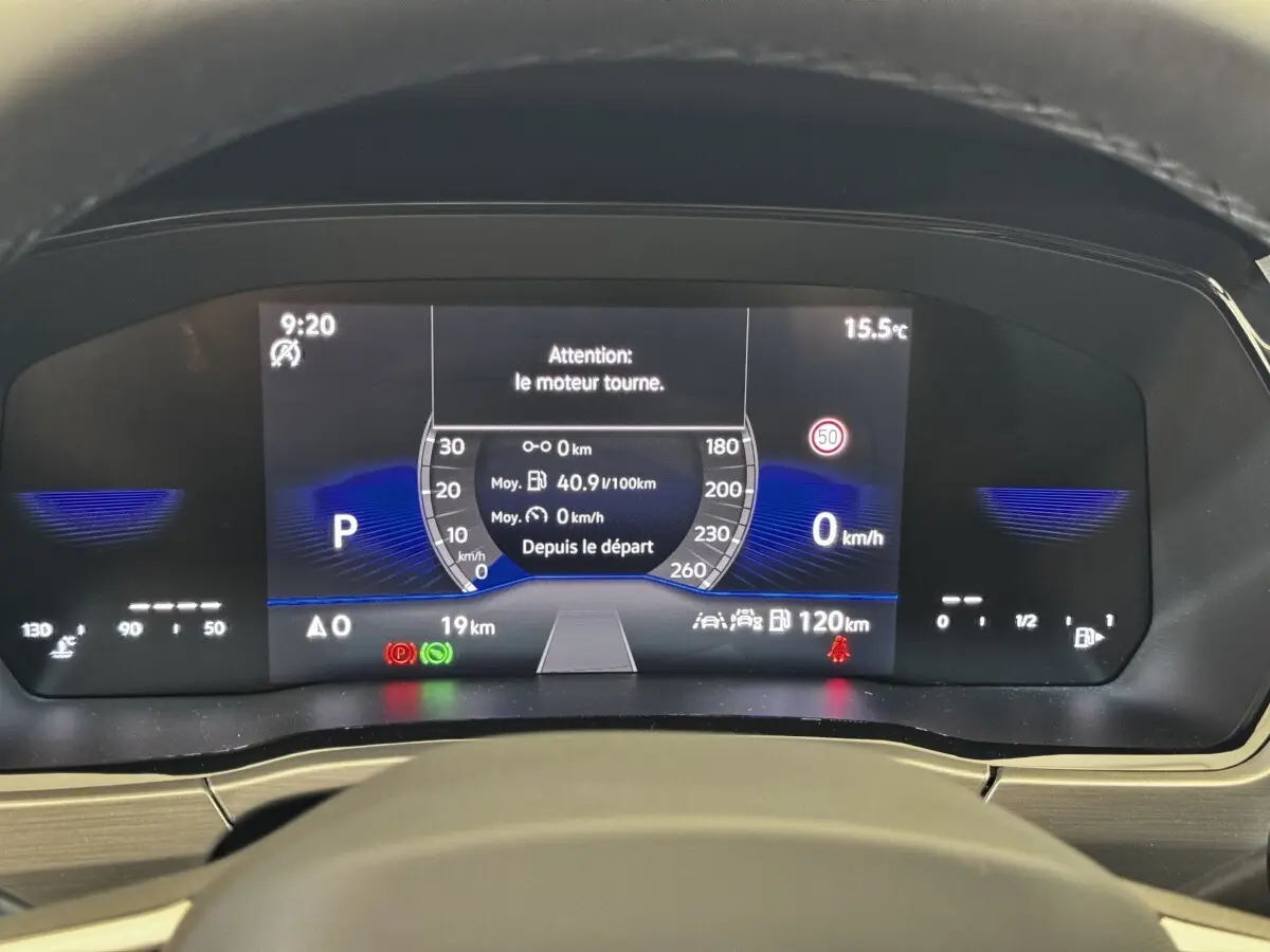 Tableau de bord numérique du Volkswagen Touran 2024 affichant la vitesse, la consommation et les alertes moteur.