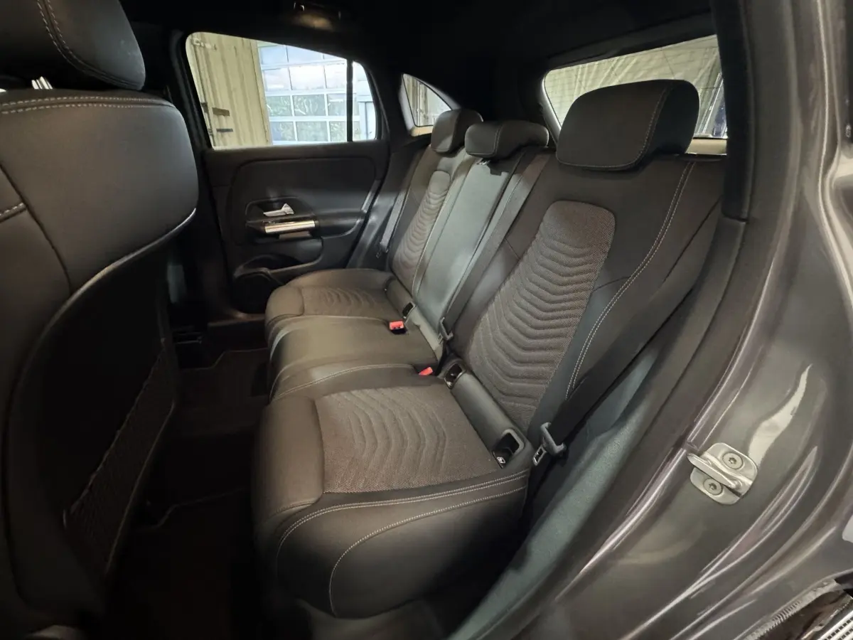 Vue intérieure côté droit montrant la banquette arrière en tissu noir du Mercedes GLA 250 e Business Line gris foncé 2023.