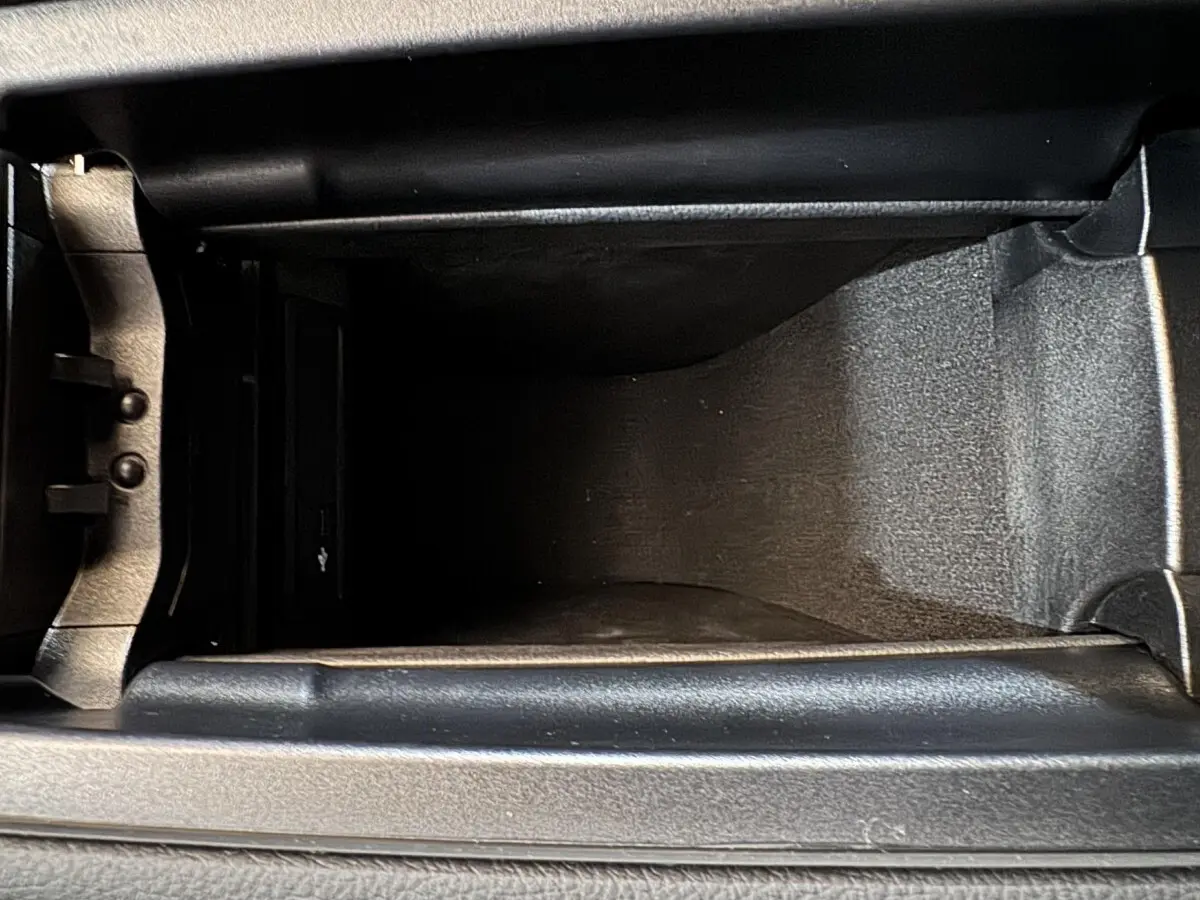 Vue rapprochée de la console centrale noire du Mercedes GLA 250 e Business Line 2023, montrant le rangement intérieur.