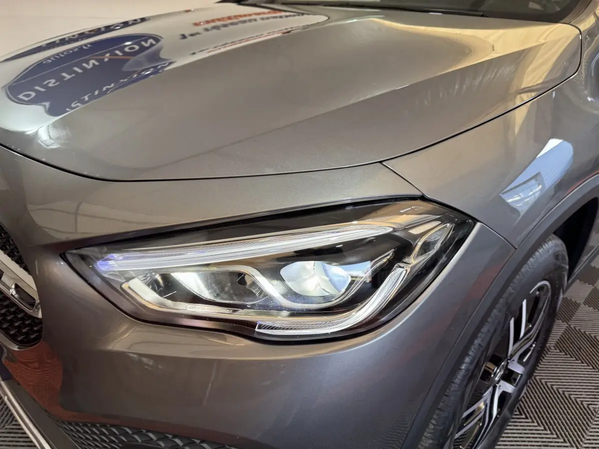 Gros plan sur le phare avant droit du Mercedes GLA 250 e Business Line gris foncé, soulignant ses détails LED modernes.