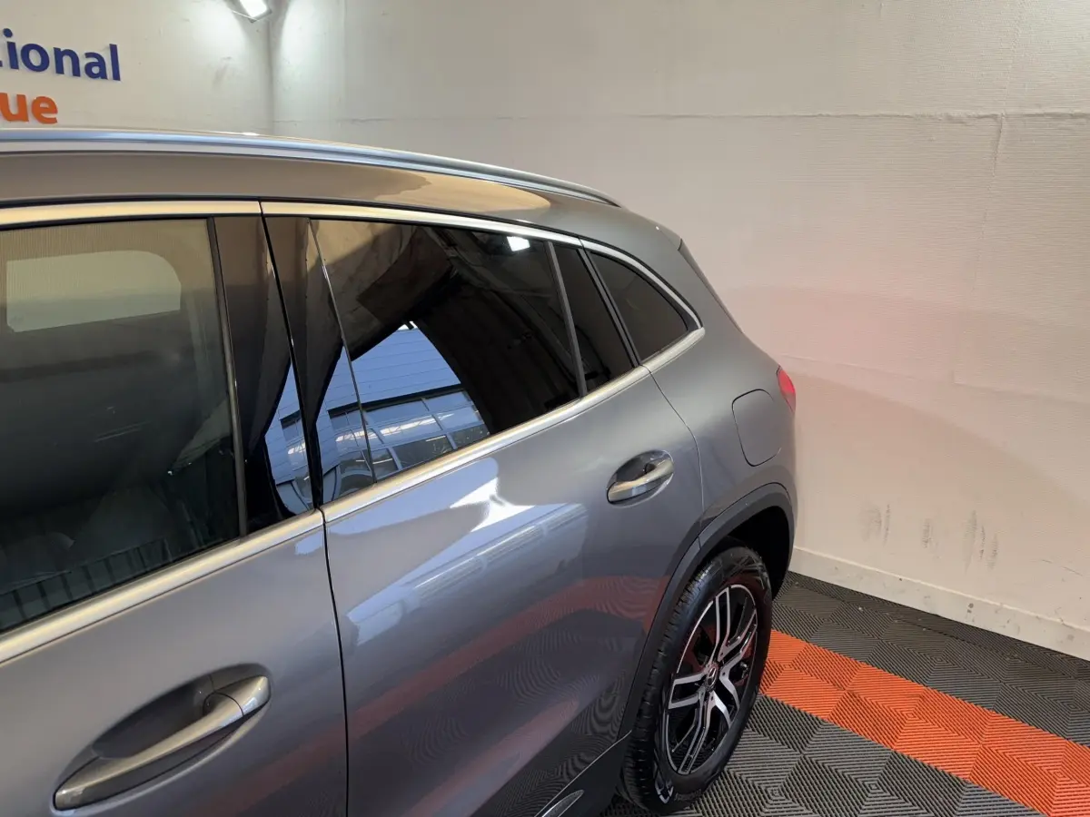 Vue 3/4 arrière côté droit d’un Mercedes GLA 250 e Business Line gris foncé avec jantes alliage et vitres teintées.