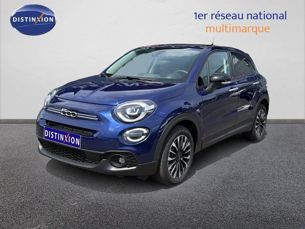 Vue 3/4 avant d'une FIAT 500X bleu Venezia avec jantes alliage bicolores et phares LED arrondis.