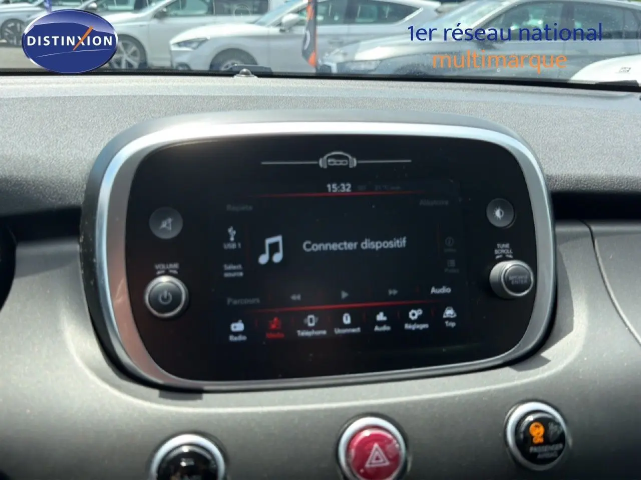 Écran tactile central de la console d’une Fiat 500X 2024, affichant l’interface multimédia avec option connecter dispositif.