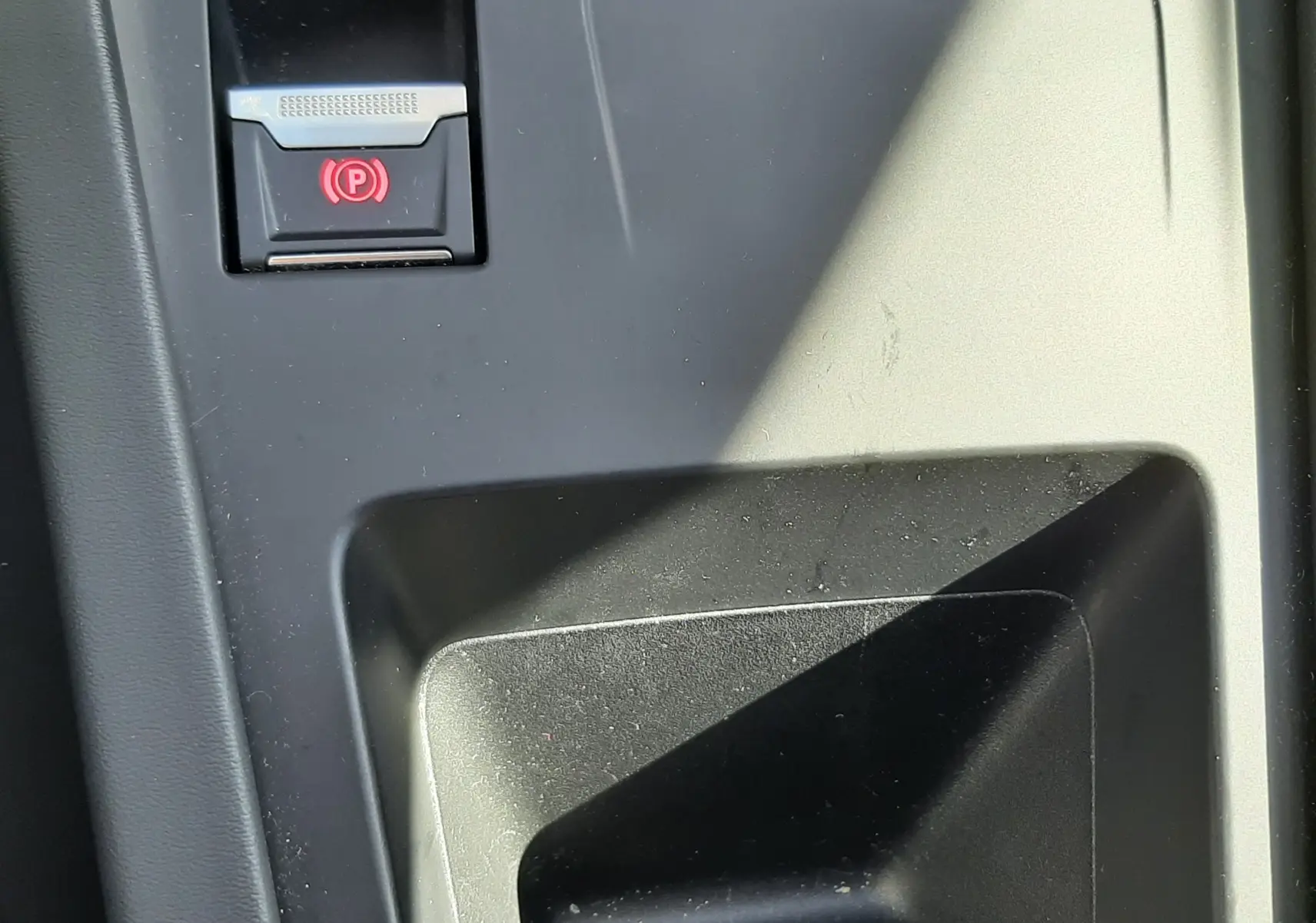 Détail de la console centrale noire avec bouton de frein à main électronique rouge sur Peugeot 308 2024 blanc.