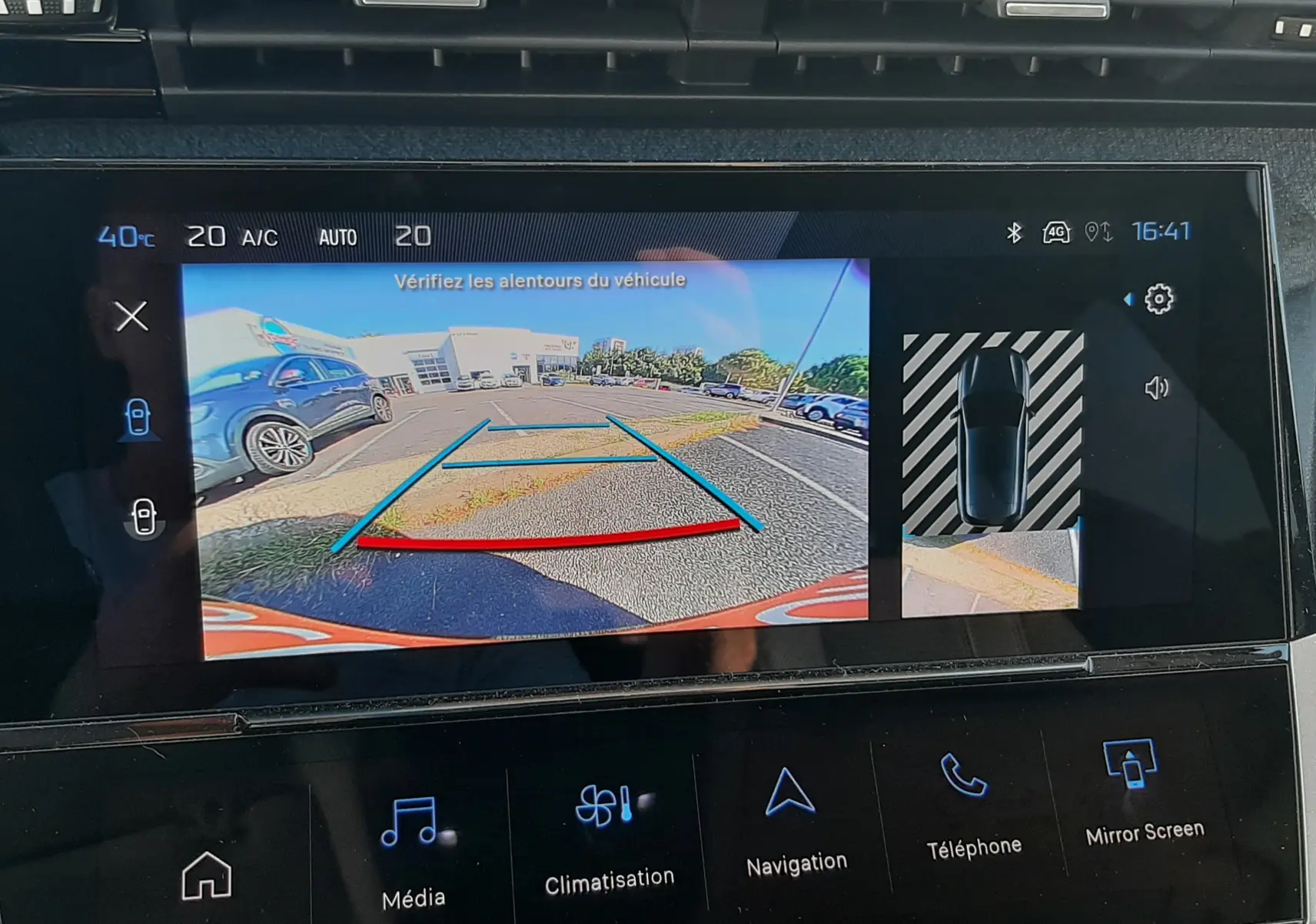 Écran multimédia de la Peugeot 308 blanc montrant la caméra de recul avec guidage et vue 360° stationnement.