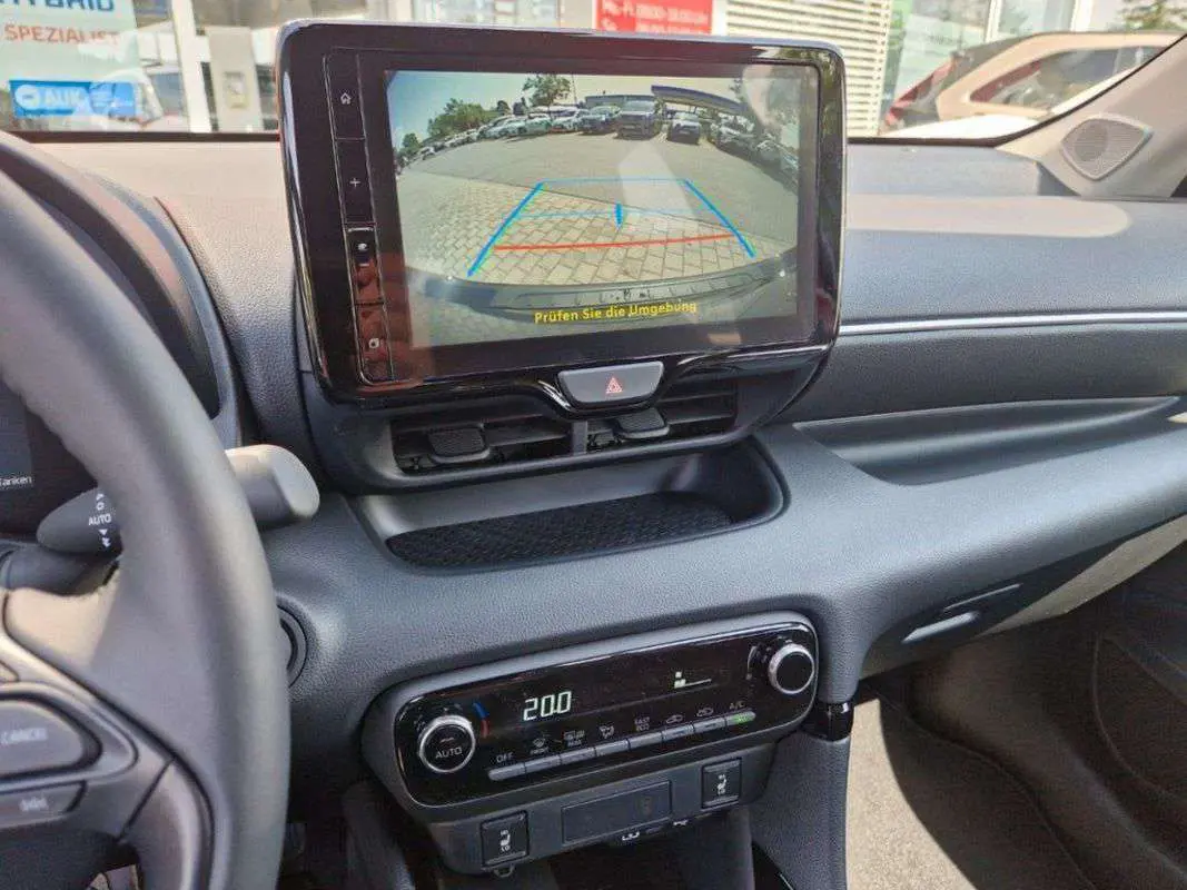 Vue intérieure du tableau de bord de la Toyota Yaris 2025 gris minéral, avec écran multimédia affichant la caméra de recul.