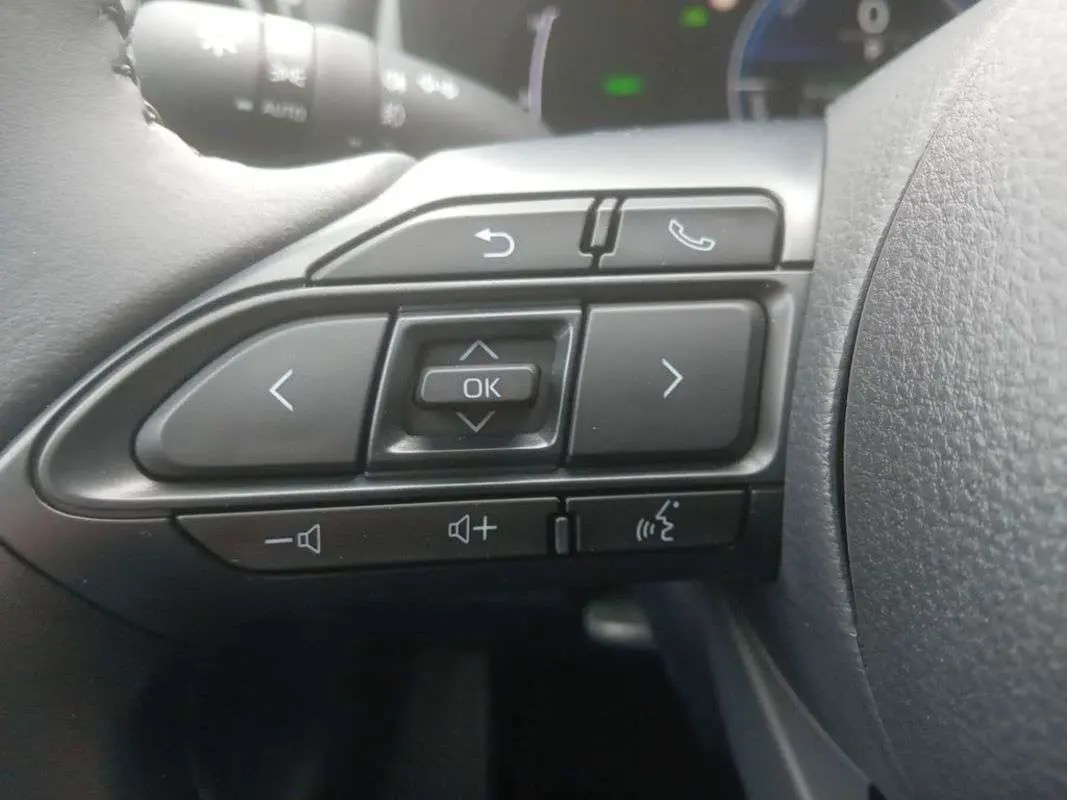 Gros plan sur les commandes au volant côté gauche de la Toyota Yaris 2025 gris minéral hybride.