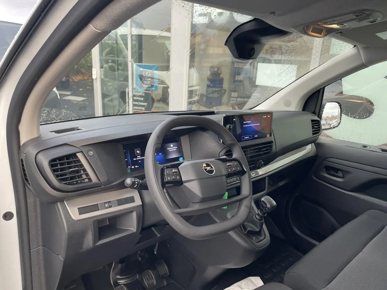 Vue intérieure côté conducteur de l'Opel Vivaro blanc 2024, avec tableau de bord moderne et écran tactile 10 pouces.
