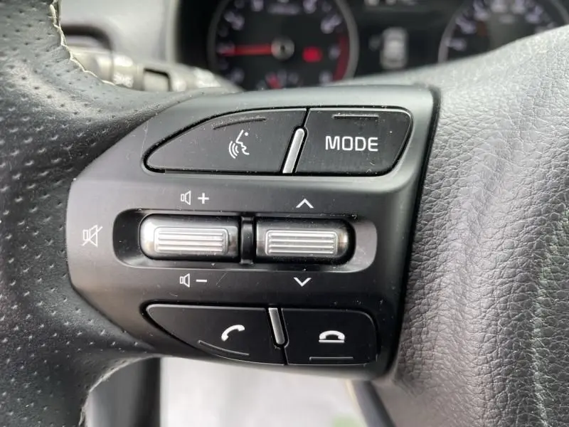 Gros plan sur les commandes au volant côté gauche d'une BMW Série 1 F20 135i bleu métal de 2013.