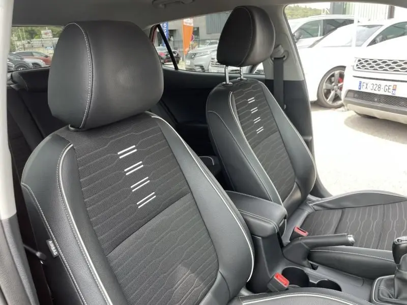 Intérieur de la BMW Série 1 F20 135i 2013, vue sur les sièges avant en tissu noir avec surpiqûres blanches.