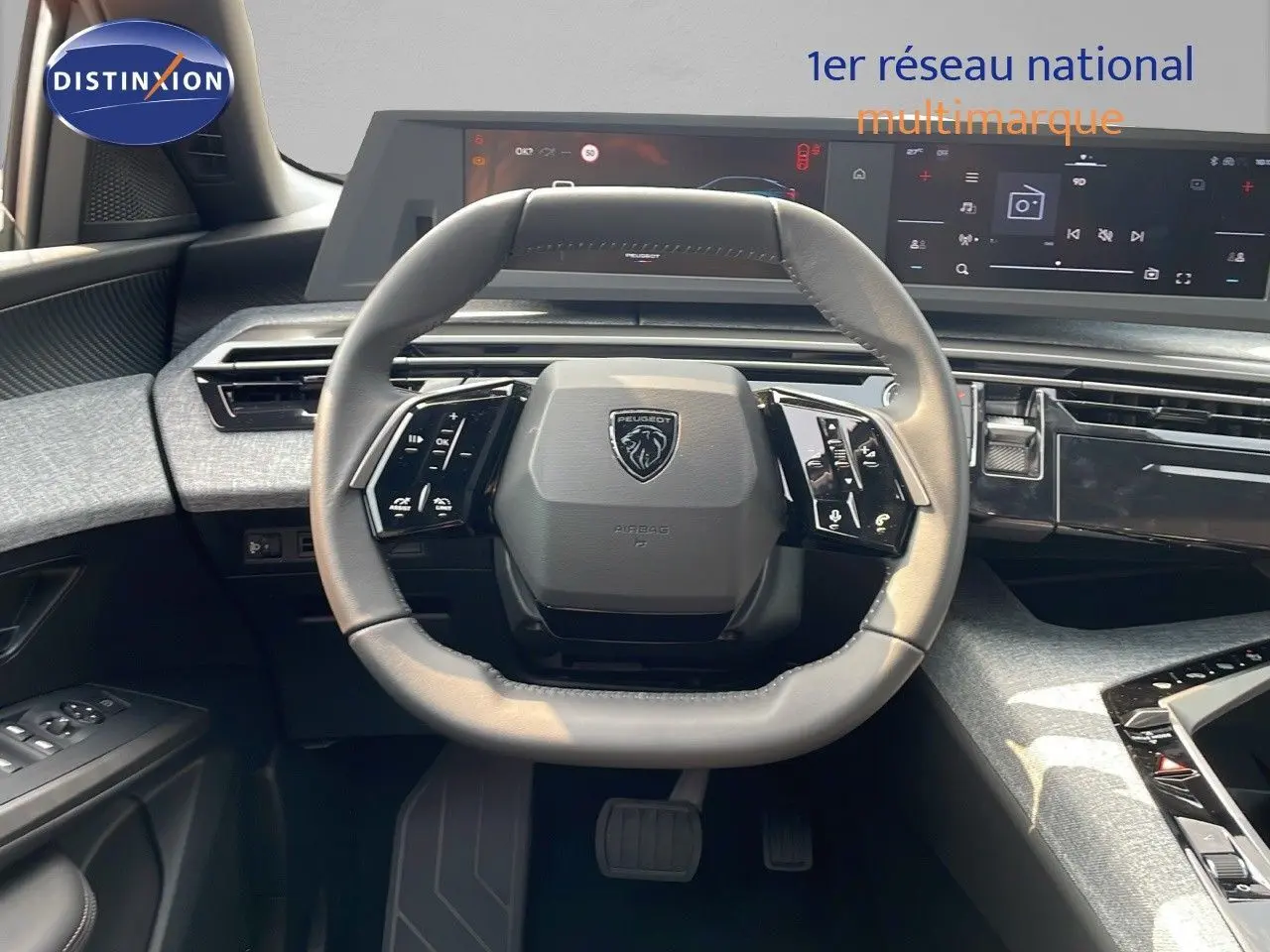 Vue intérieure centrée sur le volant gris cuir du Peugeot 3008 Hybrid 2025 avec tableau de bord numérique moderne.