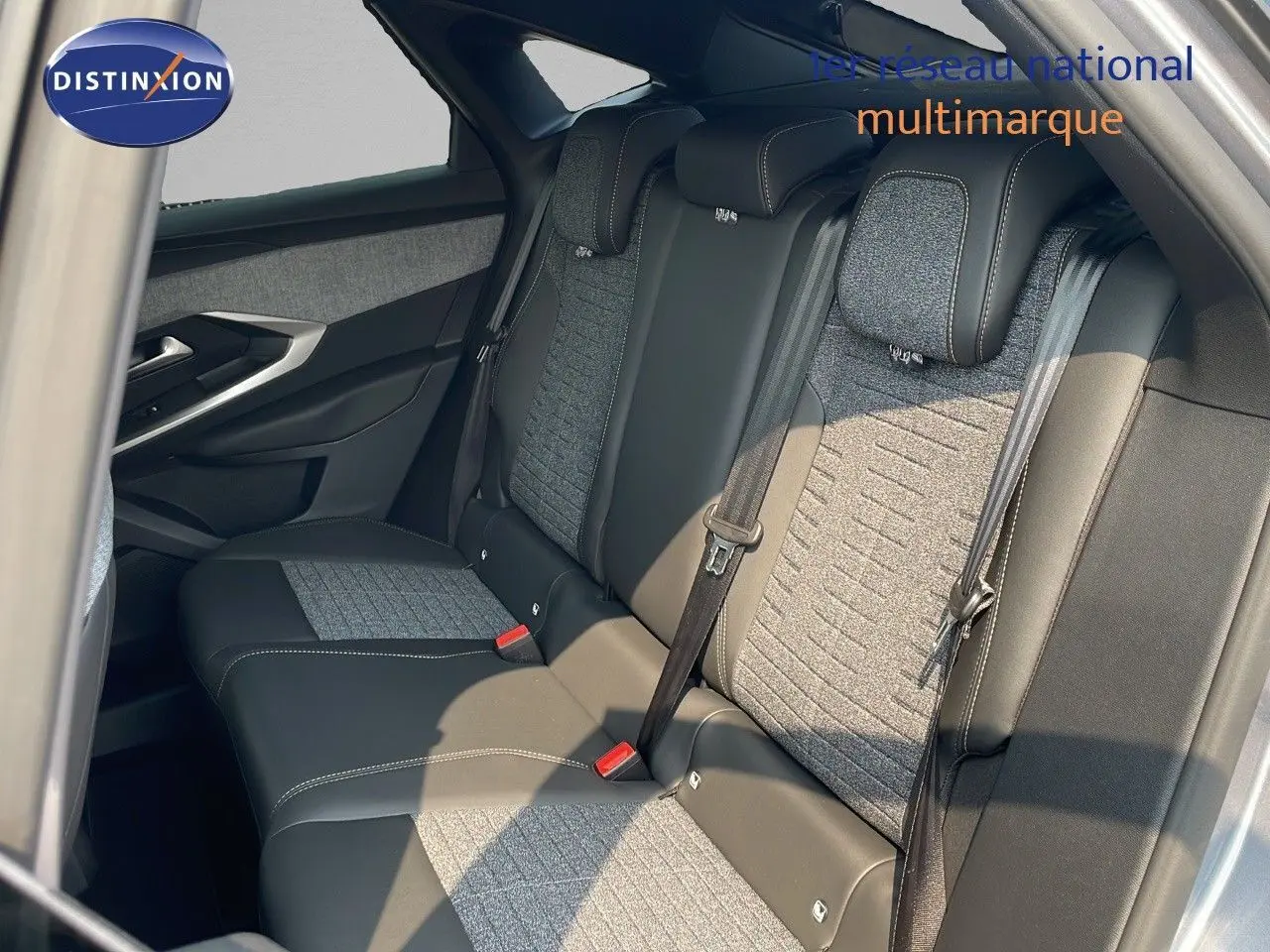 Vue latérale droite de la banquette arrière en cuir noir et tissu gris du Peugeot 3008 Hybrid 2025.